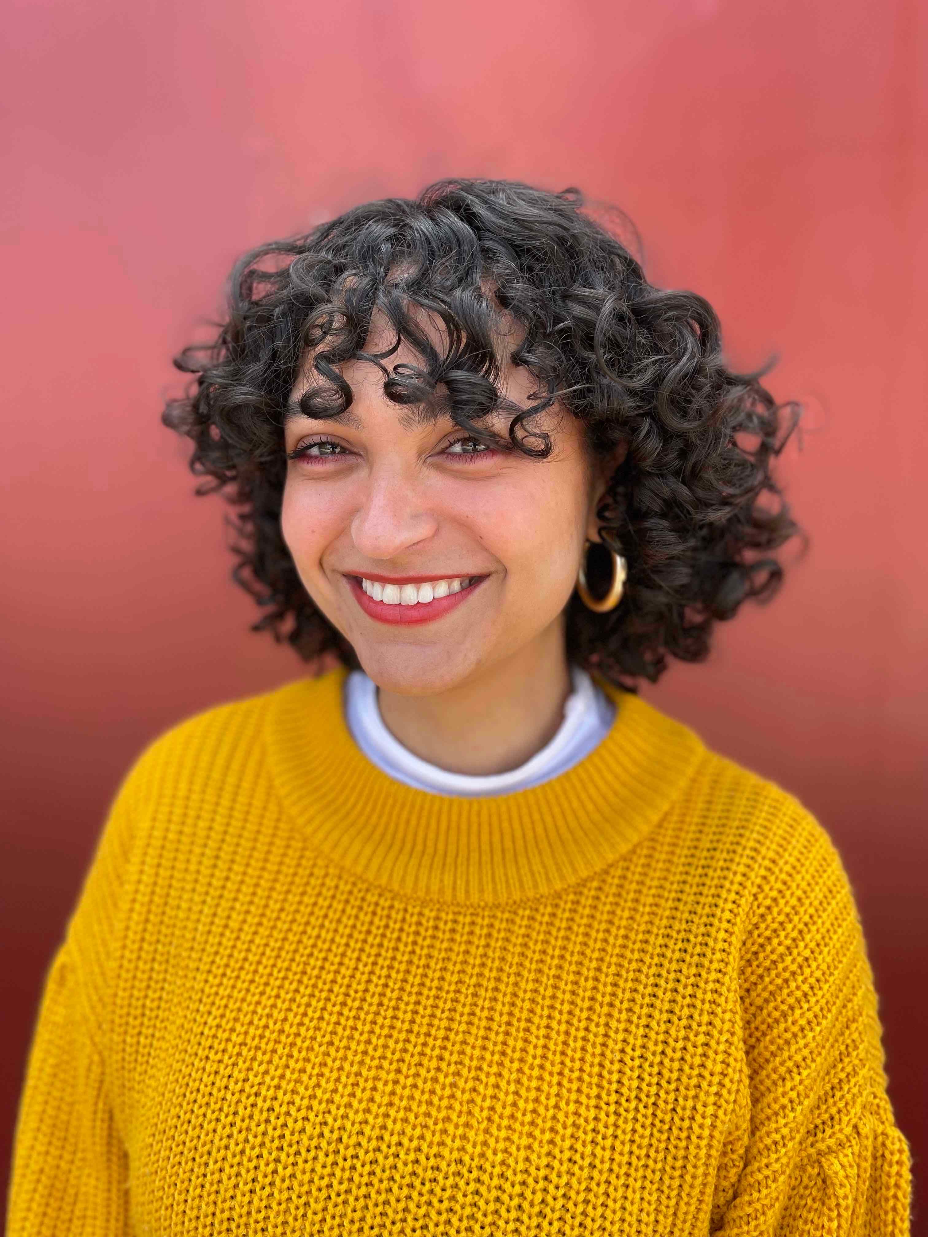 Tobi Taieb smiling in a yellow sweater